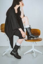 Black high aviator leather boots worn with casual outfit, lace-up military-style boots with rugged sole for everyday fashion and outdoor wear
