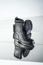 Black high aviator leather boots with rugged lug sole detail, angled view showing tread pattern and reflection for durable military-style outdoor wear